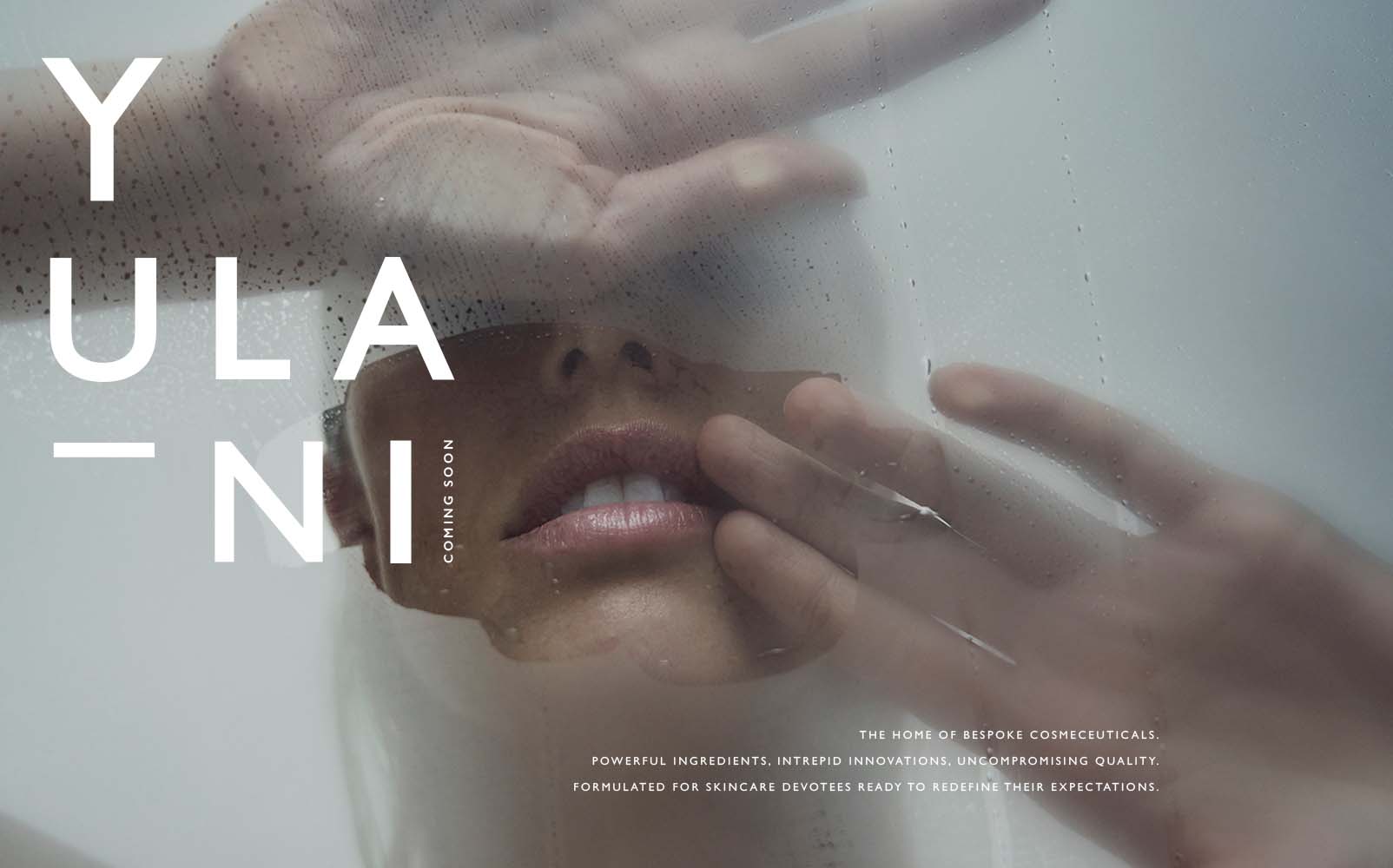 Yulani coming soon home page. Text reads, the home of bespoke cosmeceuticals. Powerful ingredients, intrepid innovation, uncompromising quality. Formulated for skincare devotees ready to redefine their expectation. Image depicts talent looking into fogged glass mirror